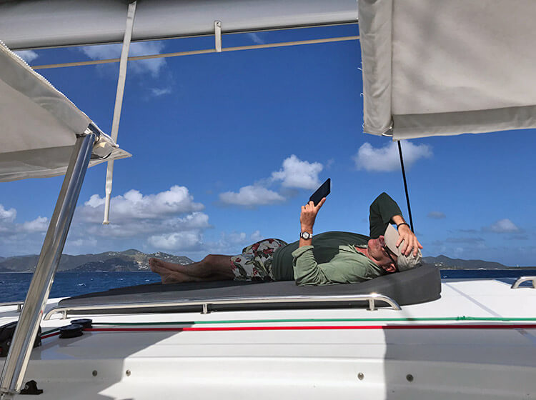 Tomando el sol y descansando en la proa de un catamaran